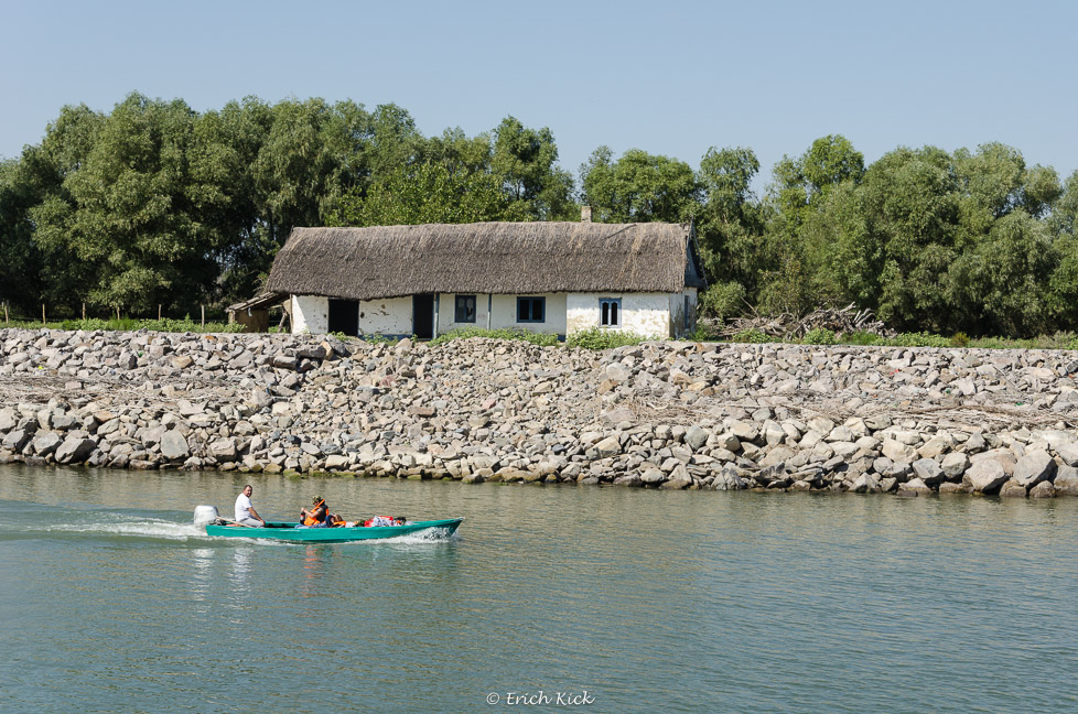 Haus am Ufer mit Motorboot